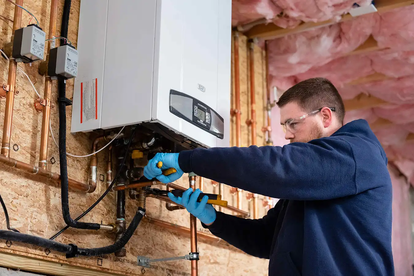 Technician making adjustments to a direct gas water heater