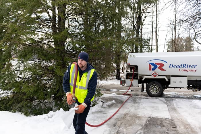 Man carrying a hose to deliver fuel